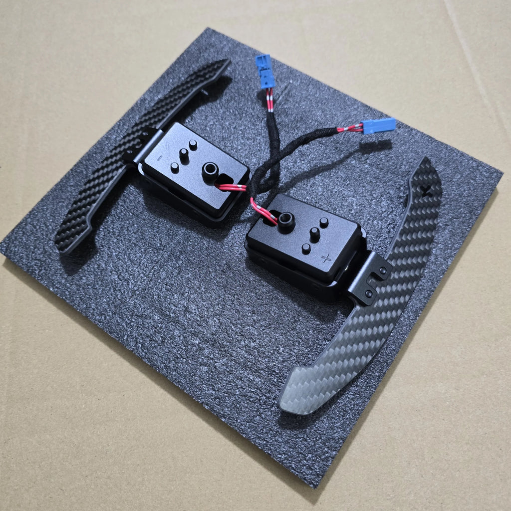 Two black electronic components on a textured gray surface