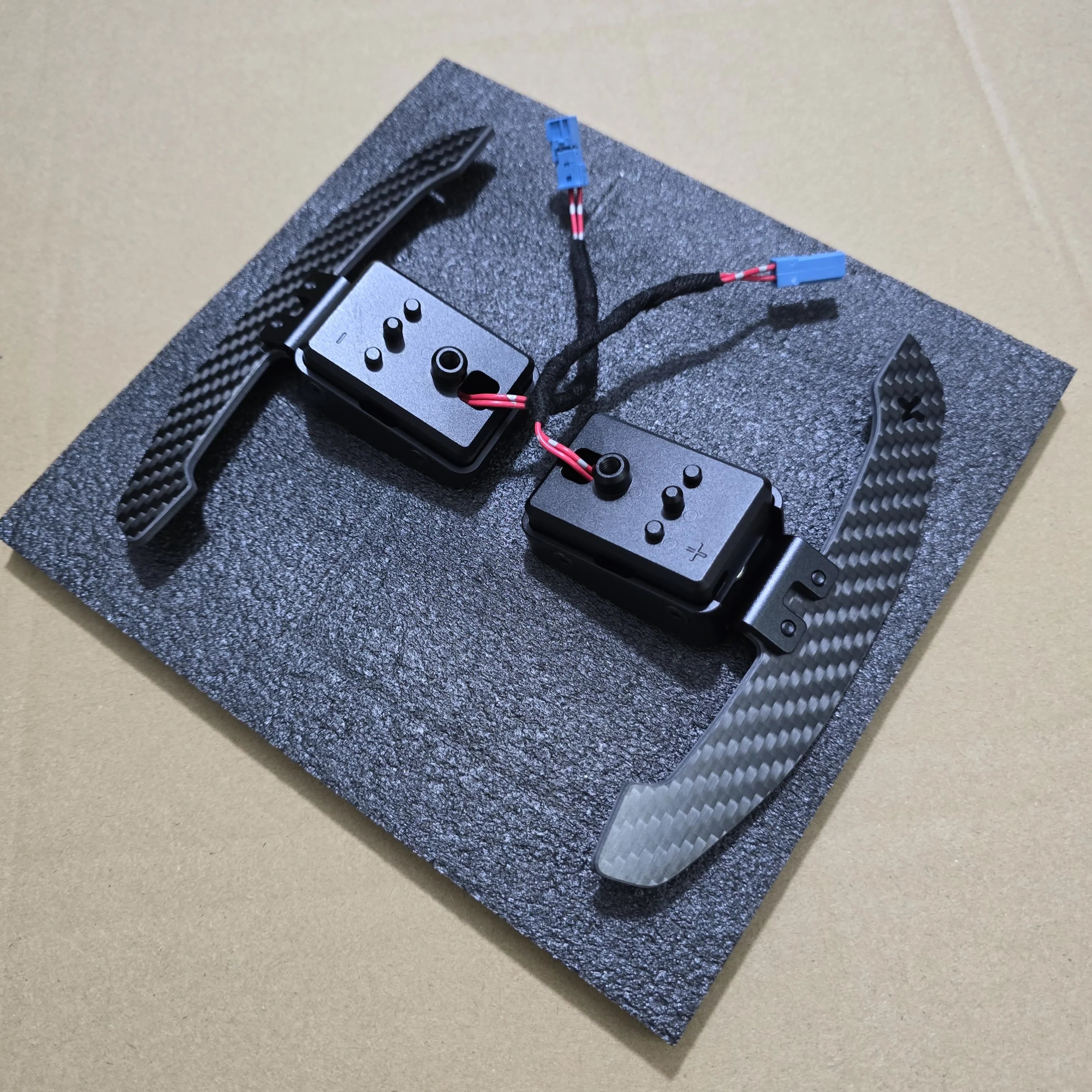 Two black electronic components on a textured gray surface