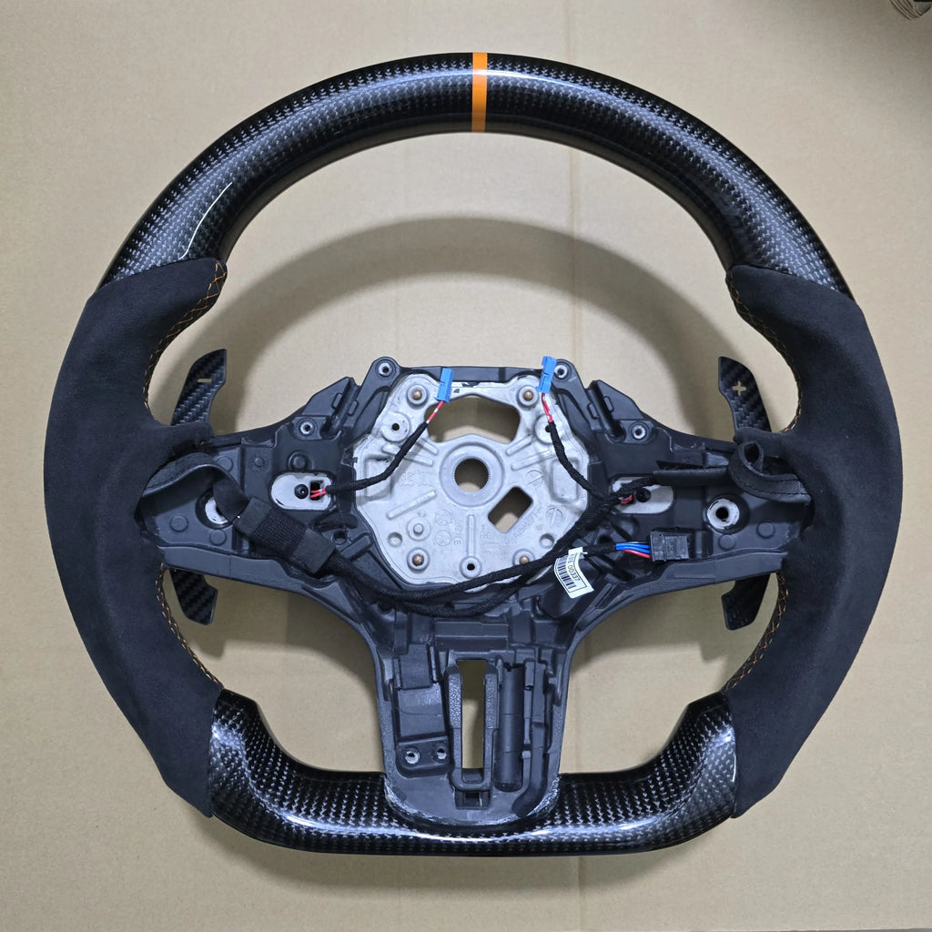 Carbon fiber steering wheel with electronic components on a beige background